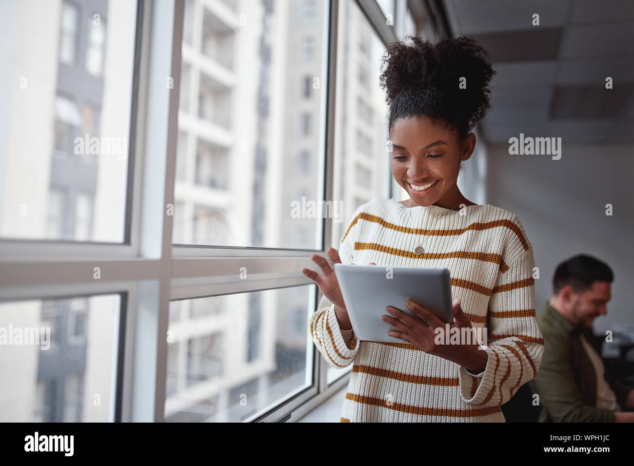 Lächelnd brasilianischen Führungskraft mit einem digitalen Tablet in einem modernen architektonischen Einstellung in Südamerika einstellen Stockfoto