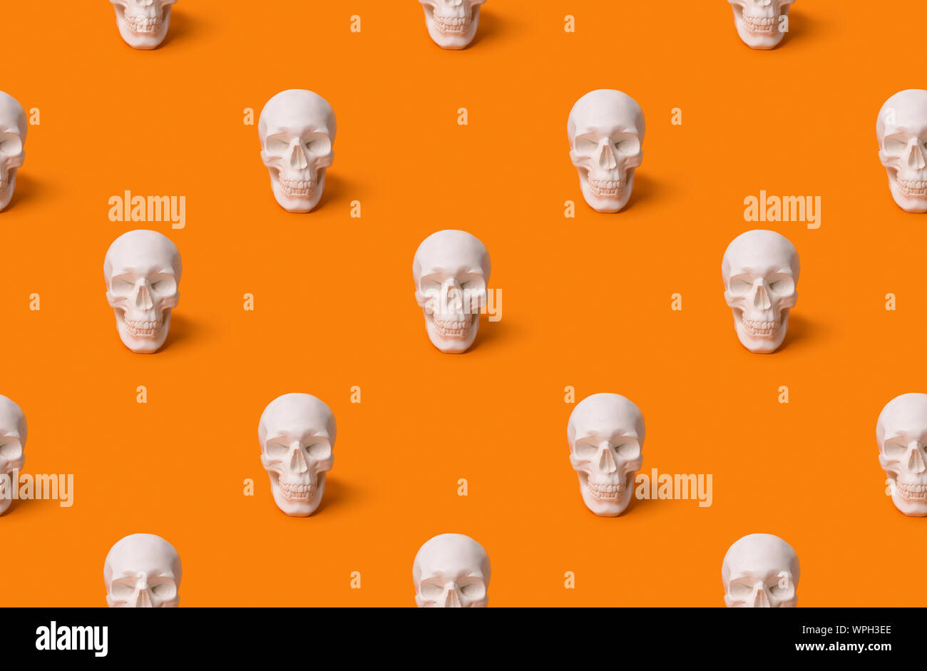 Halloween Dekorationen. Menschlicher Schädel nahtlose Muster am orange Hintergrund mit kopieren. Stockfoto