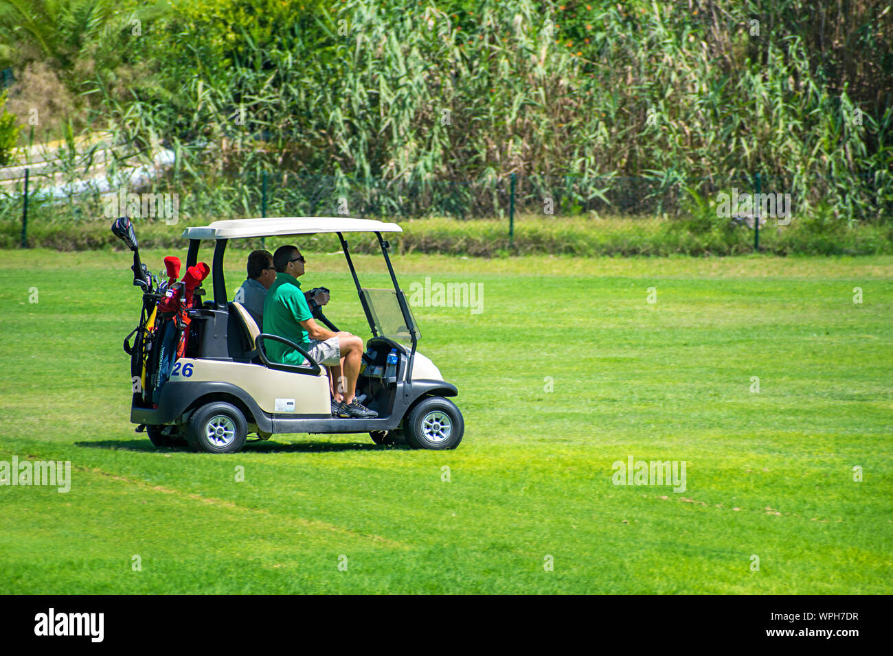 Murcia, Spanien, 25. August 2019: Sportler, ein Golf Cart in einem Spanisch-Kurs.  Zwei Männer spielen Golf spielt im Sommer. Grünes Gras, spielt  Stockfotografie - Alamy