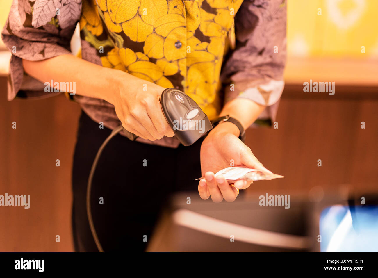 Frau an der Kasse Barcode von einem Etikett scannen. Stockfoto