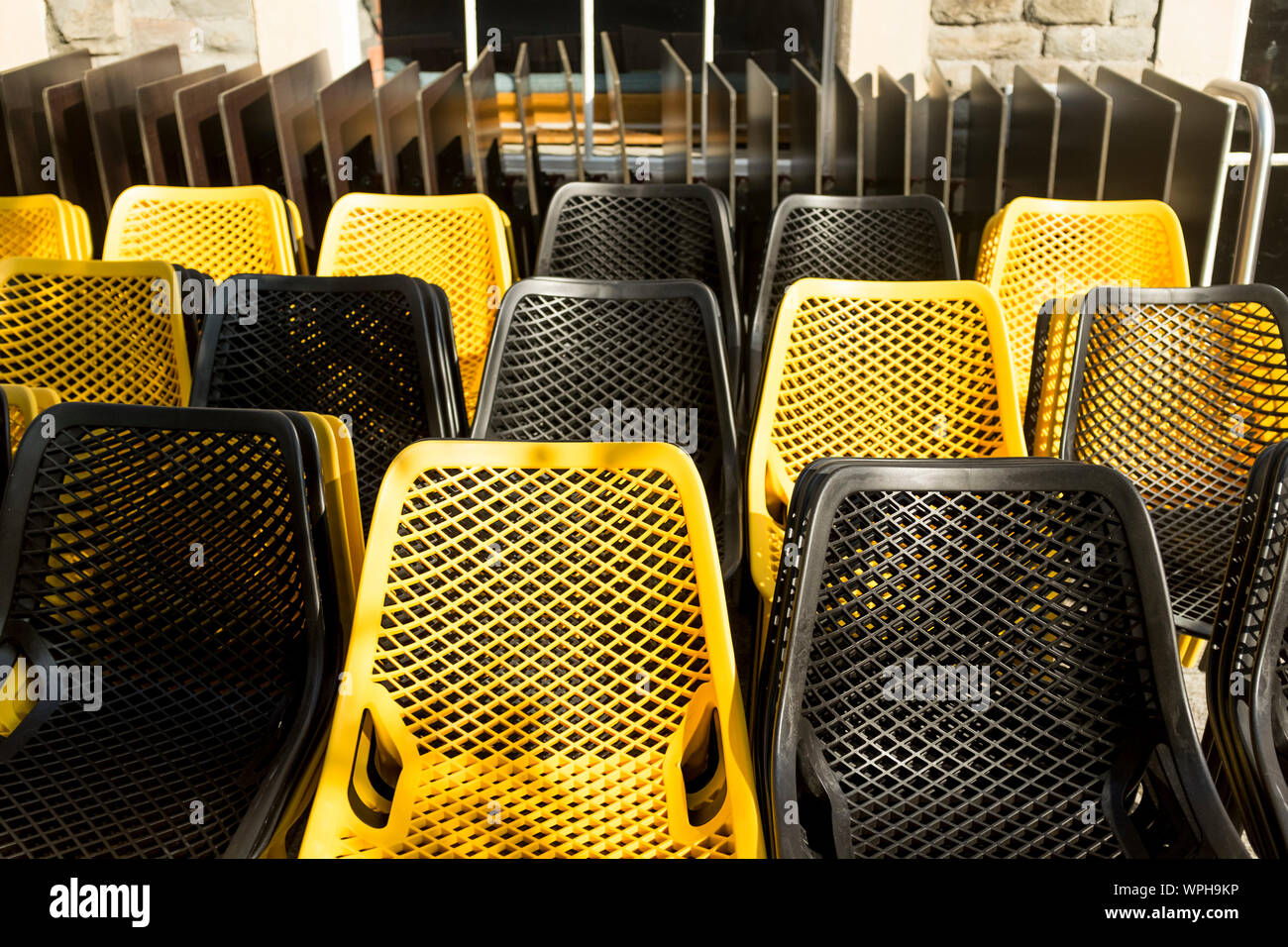 Schwarz und Gelb Kunststoff Stühle links außerhalb des Restaurant Cafe, Bristol, Großbritannien Stockfoto