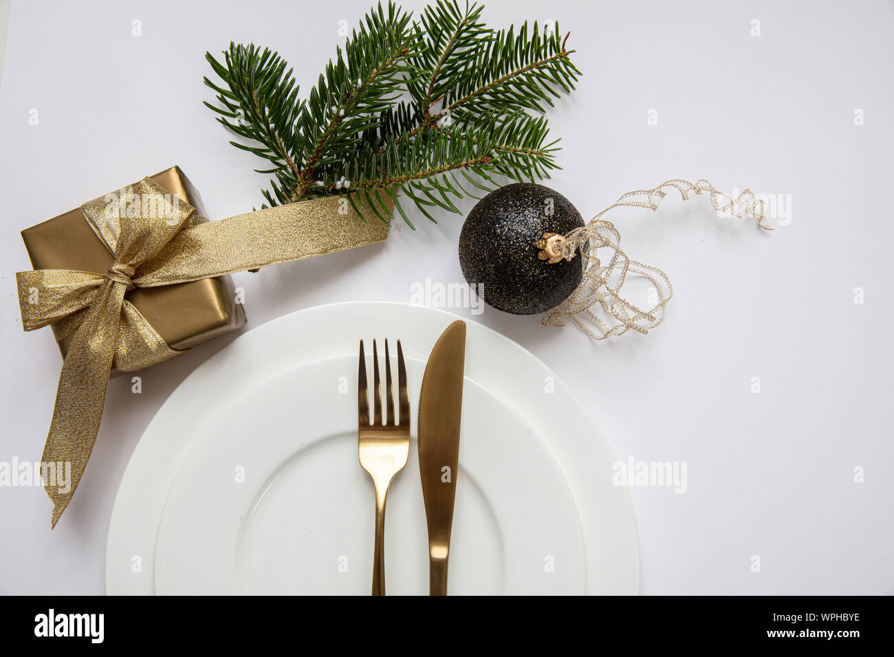 Weihnachten Tisch setzen, Gold Geschenkbox und Besteck auf weißem Geschirr, weißer Hintergrund, Ansicht von oben Stockfoto