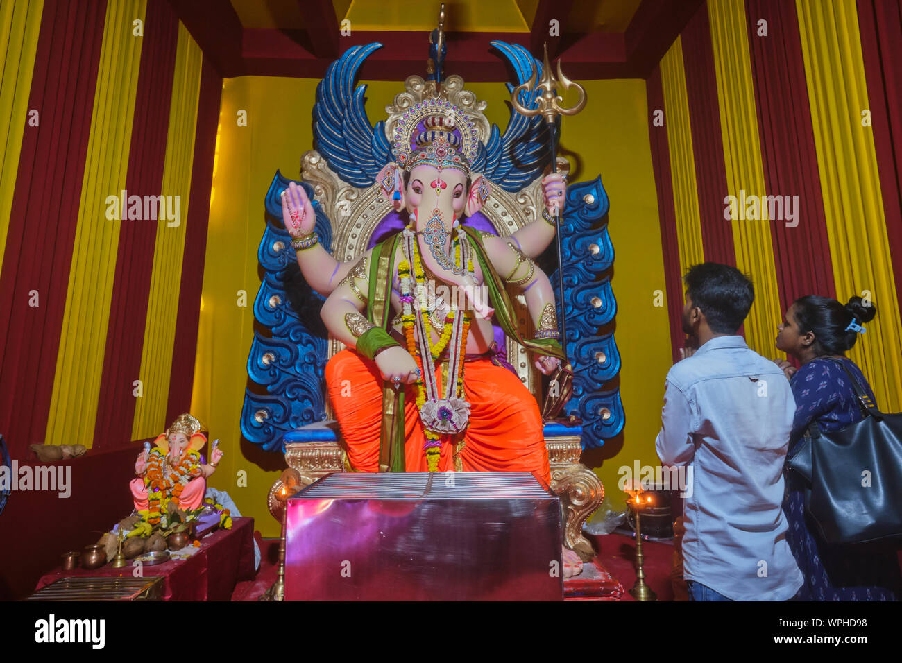 Während der 9-tägigen jährliche Ganesh Festival (Ganesh Chaturthi) in Mumbai, Indien, ein paar beten zu einem bunten Statue der Elefantengott Ganesh oder Ganpati Stockfoto