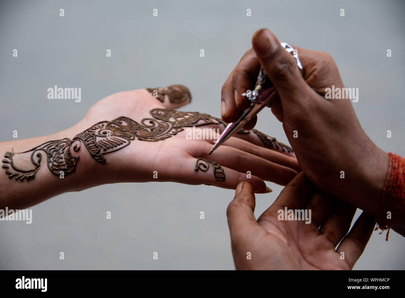 Eine Frau bringt Henna auch als 'Mehndi' auf ihre Hand an Ason, Kathmandu bekannt. Stockfoto