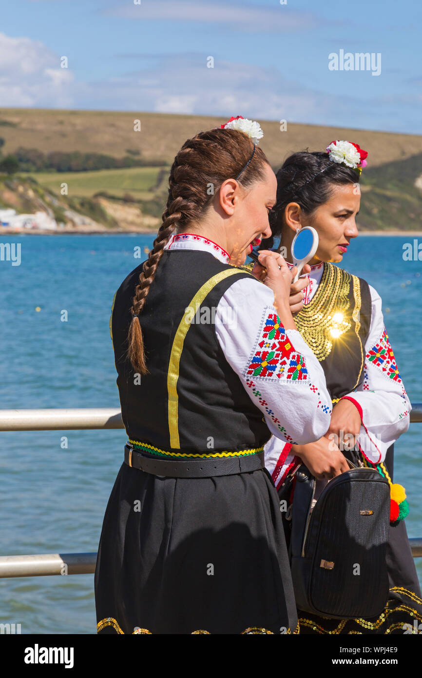 Mitglieder der Zlaten Klas dance Team machen Sie sich bereit, ihre traditionelle bulgarische Tänze in Swanage Folk Festival, Swanage, Dorset UK im September durchführen Stockfoto