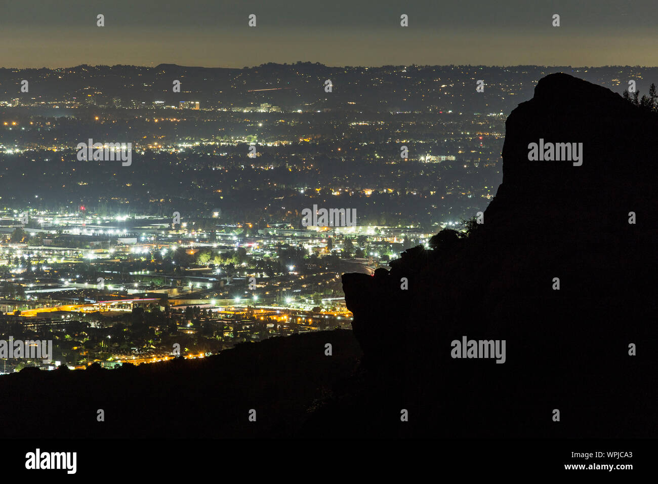 Predawn Blick über die San Fernando Valley mit Santa Susana Mountains Rock outcropping Silhouette in Los Angeles, Kalifornien. Stockfoto