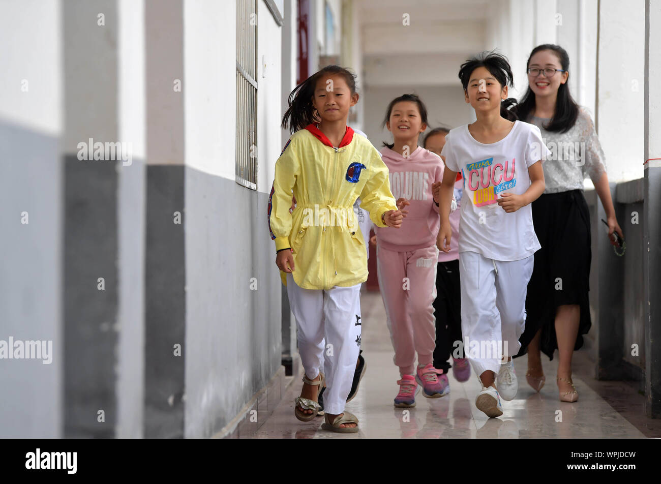 (190909) - NANCHANG, Sept. 9, 2019 (Xinhua) - Tu Youyou (1. R) und ihre Schüler zu Fuß zu einem Proberaum an Shangban Grundschule in Luoting Township, Wanli Bezirk von Nanchang City, der ostchinesischen Provinz Jiangxi, Sept. 2, 2019. Nach dem Abitur in 2013 von der normalen Ausbildung, Tu arbeitete als Assistent in einer Ausbildungseinrichtung und Gemeinschaft funktionieren, aber Sie hat immer davon geträumt, ein Lehrer. Im Jahr 2016 legte sie der Lehrer Einstellung Prüfung der Provinz Jiangxi und wurde zu einem ländlichen Lehrer. In den letzten drei Jahren, Tu Youyou hat die Anerkennung der Eltern ihrer Schüler" gewonnen. Stockfoto