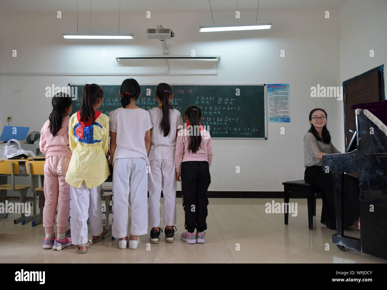 (190909) - NANCHANG, Sept. 9, 2019 (Xinhua) - Tu Youyou (1. R) spielt eine Begleitung für Schülerinnen und Schüler der Grundschule in Shangban Luoting Township, Wanli Bezirk von Nanchang City, der ostchinesischen Provinz Jiangxi, Sept. 2, 2019. Nach dem Abitur in 2013 von der normalen Ausbildung, Tu arbeitete als Assistent in einer Ausbildungseinrichtung und Gemeinschaft funktionieren, aber Sie hat immer davon geträumt, ein Lehrer. Im Jahr 2016 legte sie der Lehrer Einstellung Prüfung der Provinz Jiangxi und wurde zu einem ländlichen Lehrer. In den letzten drei Jahren, Tu Youyou hat die Anerkennung der Eltern ihrer Schüler" gewonnen. Nun, t Stockfoto