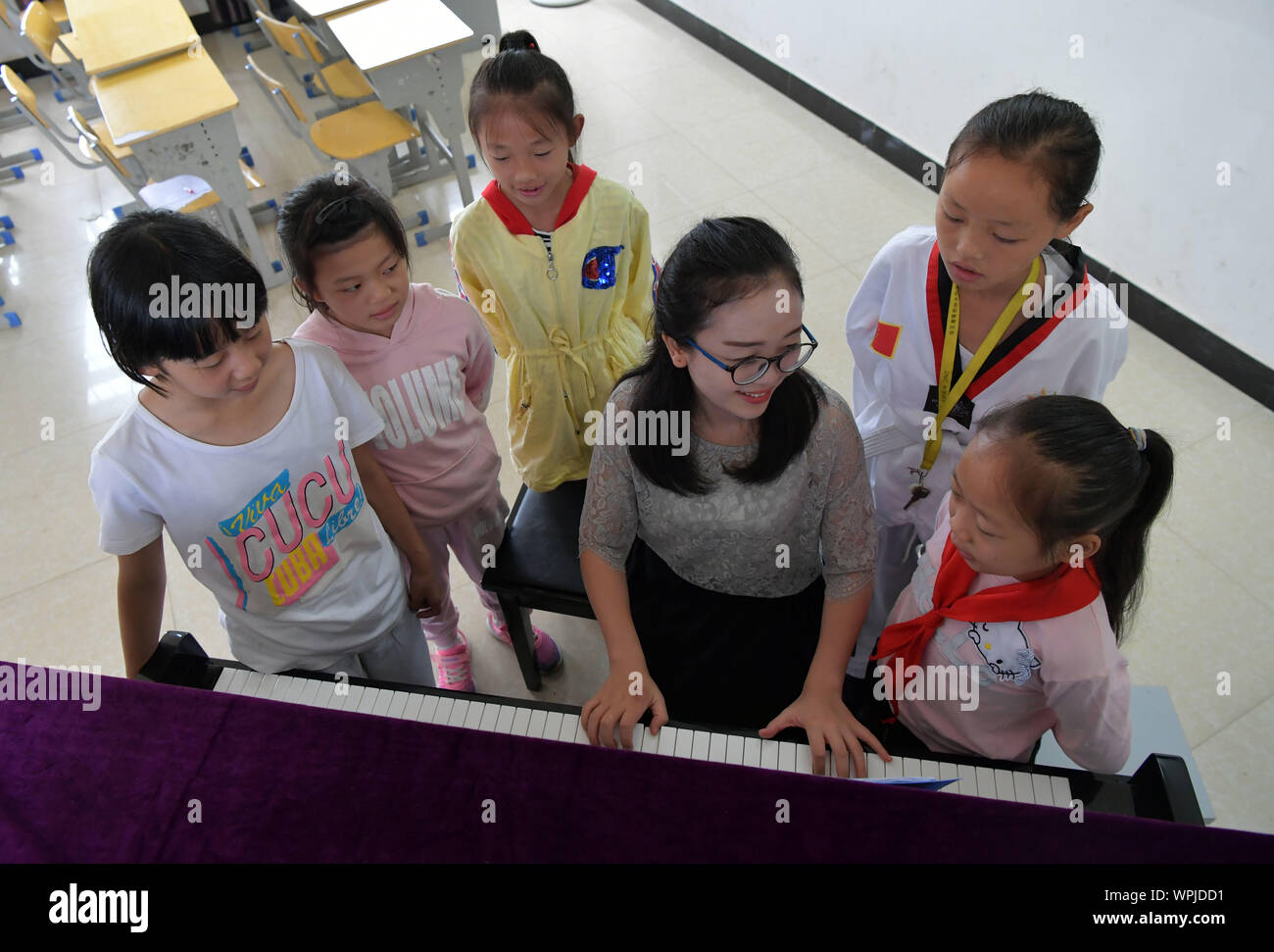(190909) - NANCHANG, Sept. 9, 2019 (Xinhua) - Tu Youyou (3. R) spielt das Klavier für die Schülerinnen und Schüler der Grundschule in Shangban Luoting Township, Wanli Bezirk von Nanchang City, der ostchinesischen Provinz Jiangxi, Sept. 2, 2019. Nach dem Abitur in 2013 von der normalen Ausbildung, Tu arbeitete als Assistent in einer Ausbildungseinrichtung und Gemeinschaft funktionieren, aber Sie hat immer davon geträumt, ein Lehrer. Im Jahr 2016 legte sie der Lehrer Einstellung Prüfung der Provinz Jiangxi und wurde zu einem ländlichen Lehrer. In den letzten drei Jahren, Tu Youyou hat die Anerkennung der Eltern ihrer Schüler" gewonnen. Nun, die 29-y Stockfoto