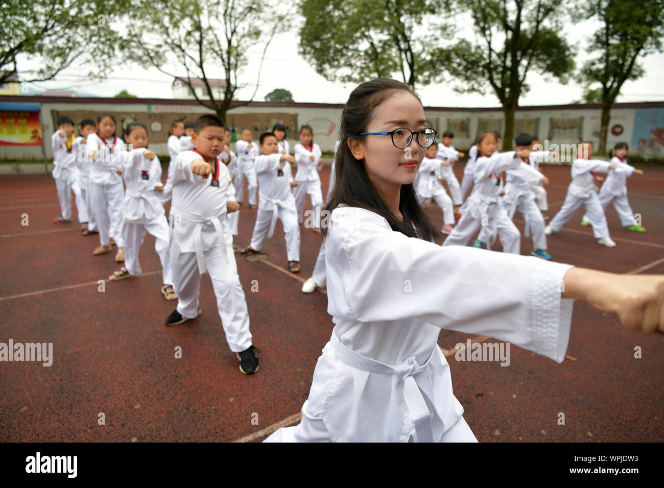 (190909) - NANCHANG, Sept. 9, 2019 (Xinhua) - Tu Youyou (vorne) unterrichtet Kursteilnehmer taekwondo an Shangban Grundschule in Luoting Township, Wanli Bezirk von Nanchang Stadt, im Osten der chinesischen Provinz Jiangxi, Sept. 2, 2019. Nach dem Abitur in 2013 von der normalen Ausbildung, Tu arbeitete als Assistent in einer Ausbildungseinrichtung und Gemeinschaft funktionieren, aber Sie hat immer davon geträumt, ein Lehrer. Im Jahr 2016 legte sie der Lehrer Einstellung Prüfung der Provinz Jiangxi und wurde zu einem ländlichen Lehrer. In den letzten drei Jahren, Tu Youyou hat die Anerkennung der Eltern ihrer Schüler" gewonnen. Nun, die 29-Ja Stockfoto