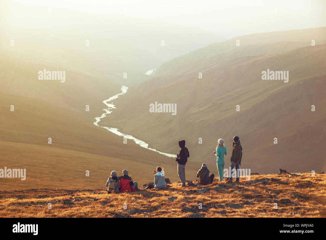 Große Gruppe von Freunden, Touristen oder Wanderer am Berg oben oder Viewpoint bei Sonnenuntergang entspannen Stockfoto