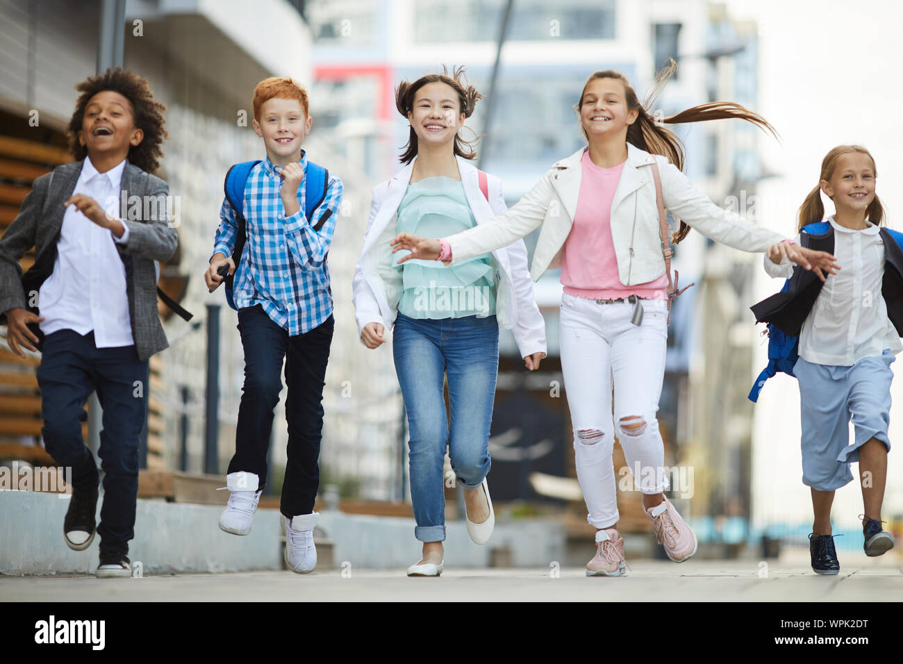 Gruppe der glückliche Kinder in Freizeitkleidung lächelnd und zusammen, die in der Stadt im Freien Stockfoto