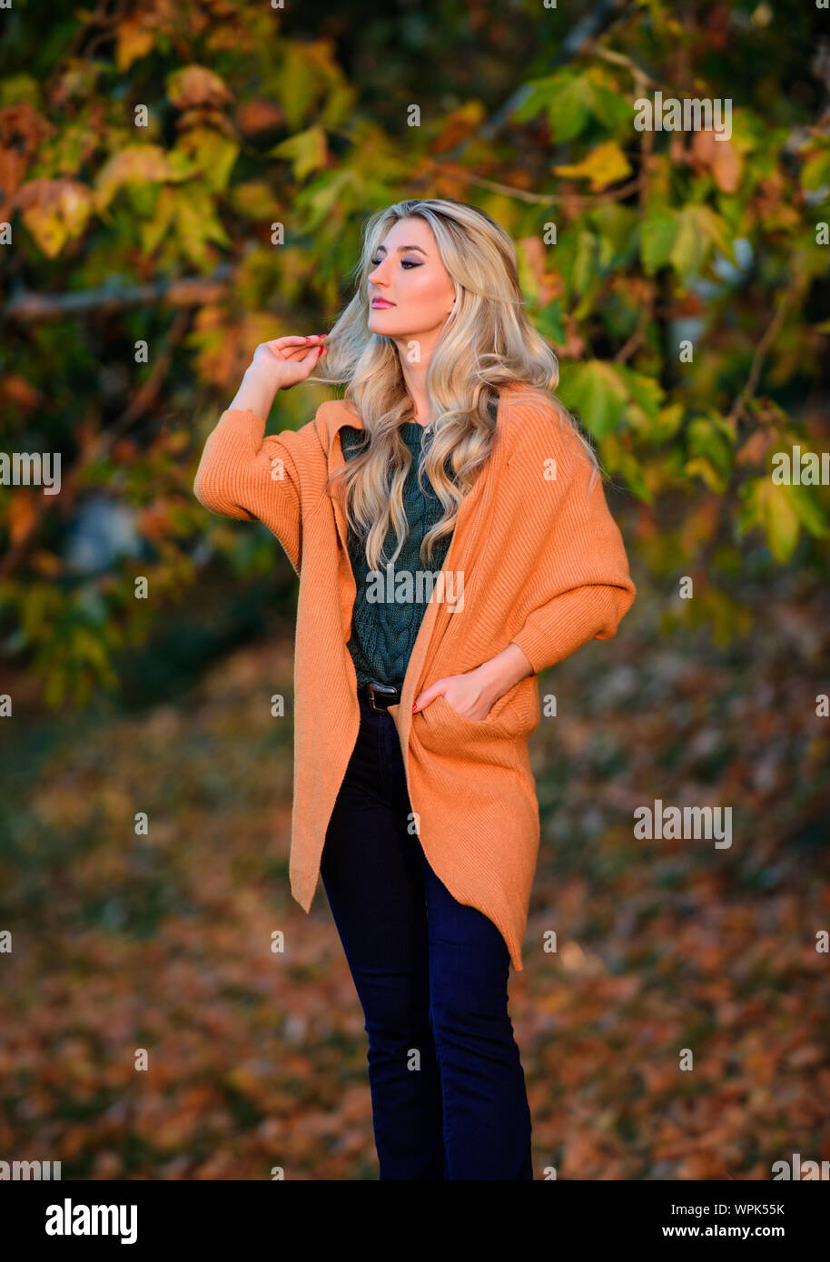 Gemütliche zwanglose Outfits für den Herbst. Gemütlich und komfortabel. Gemütliche outfit Ideen für das Wochenende. Mädchen niedliche Blondine posiert in warmen und gemütlichen Outfit Herbst Natur Hintergrund Defokussierten. Frau Spaziergang bei Sonnenuntergang. Stockfoto