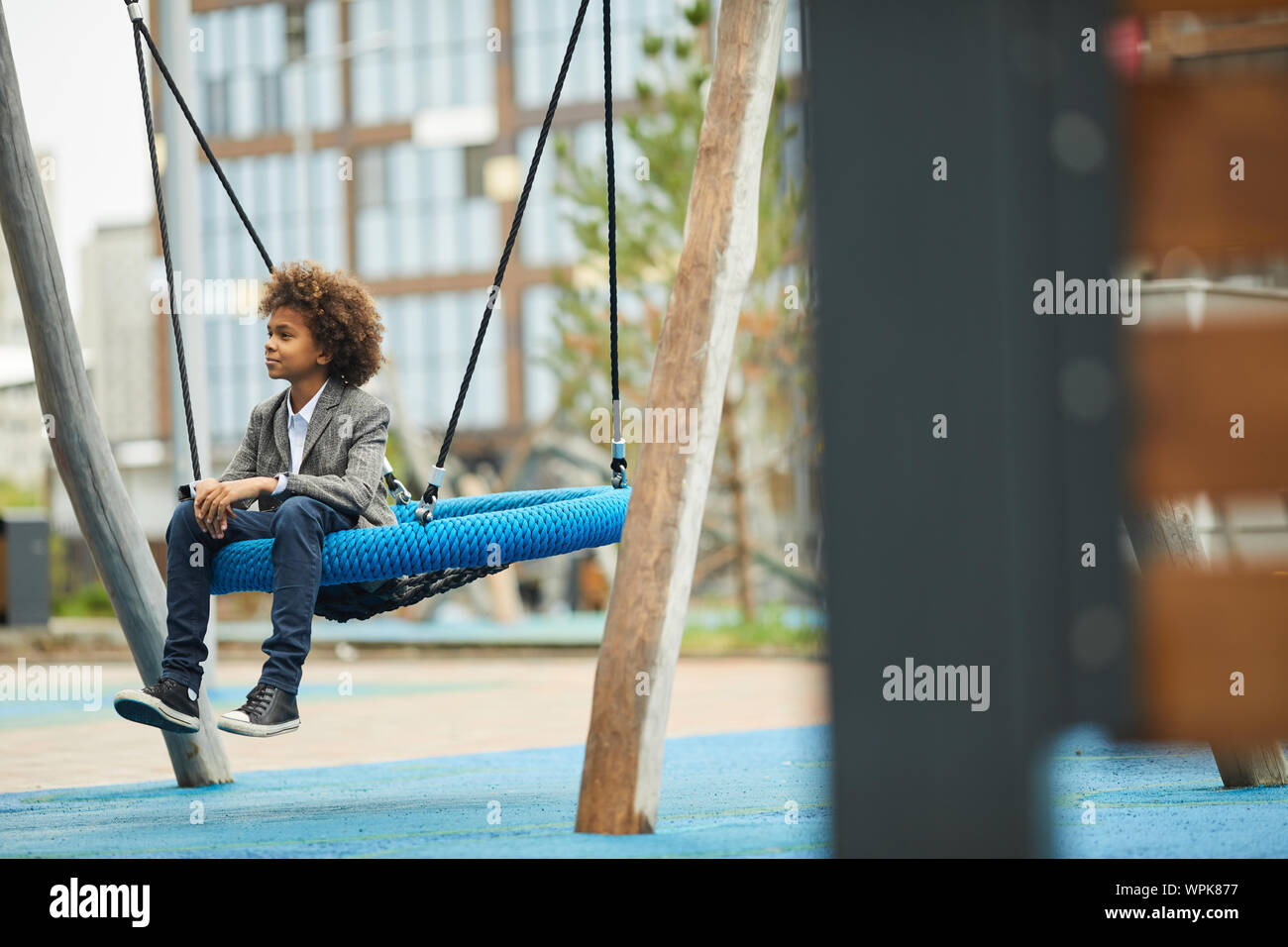 Afrikanischen jungen Schwingen auf, die er während seiner Freizeit auf dem Spielplatz im Freien Schwingen Stockfoto