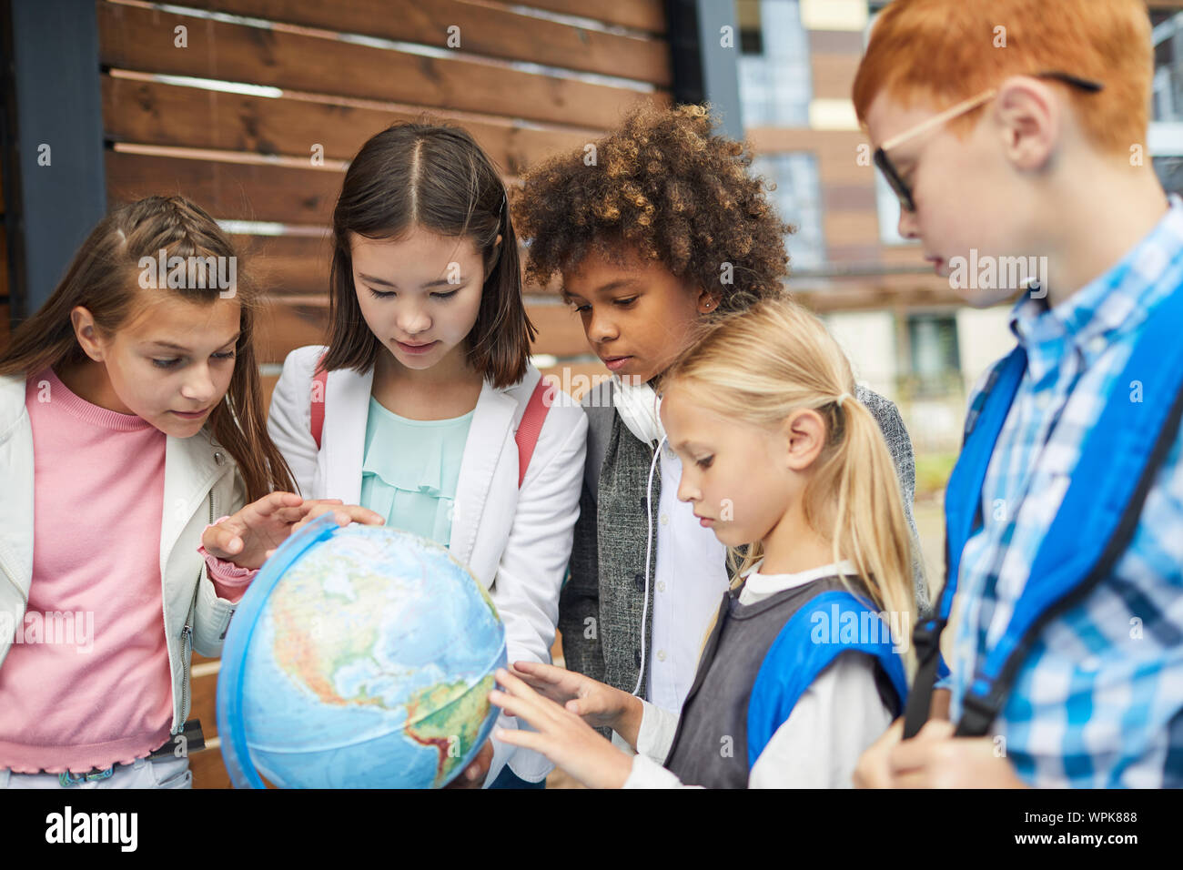 Gruppe von multiethnischen Schule Kinder im Globe zeigen Sie lernen die Geographie des Landes Stockfoto