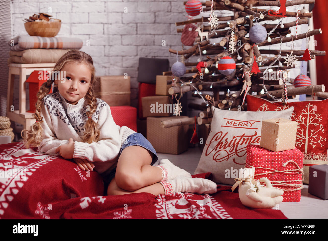 Mädchen Schwester Freunde umarmen sitzen am Weihnachtsbaum, das Konzept der Kindheit, Weihnachten und Neujahr, auf hellem Hintergrund Stockfoto