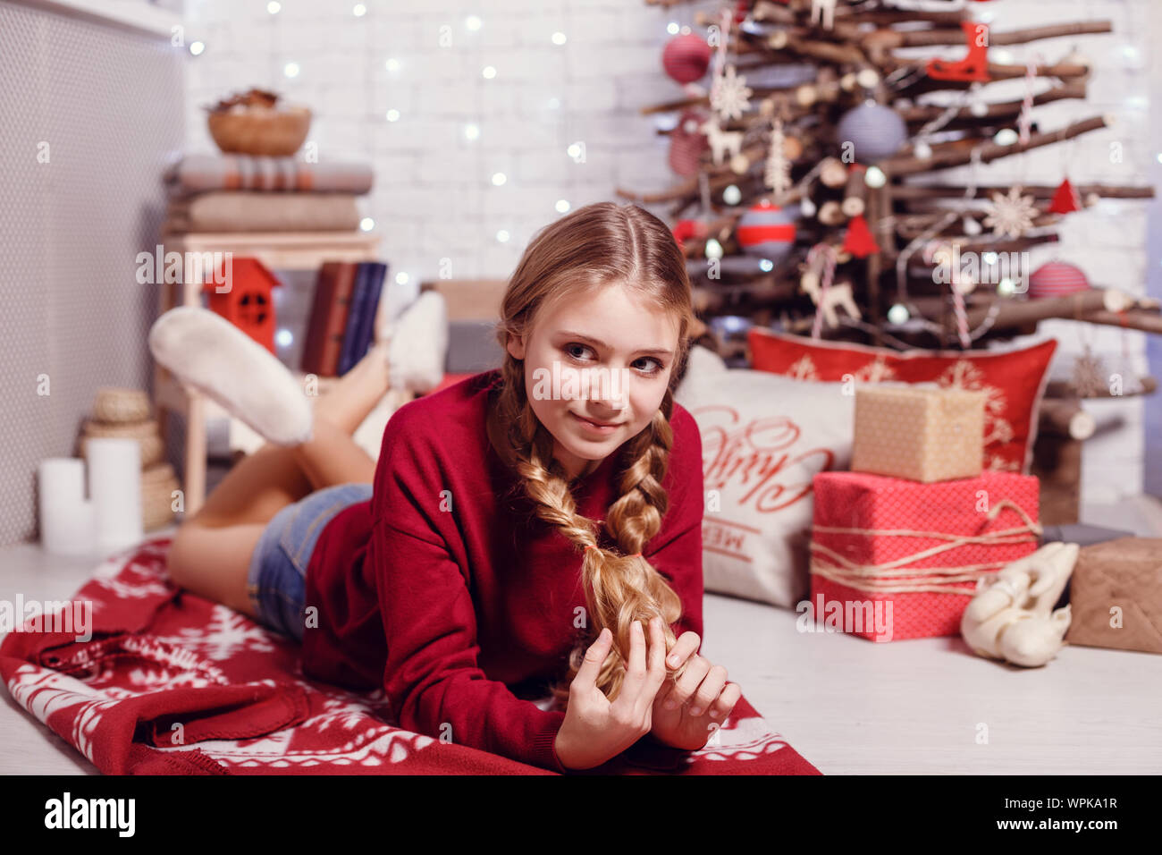 Mädchen Schwester Freunde umarmen sitzen am Weihnachtsbaum, das Konzept der Kindheit, Weihnachten und Neujahr, auf hellem Hintergrund Stockfoto