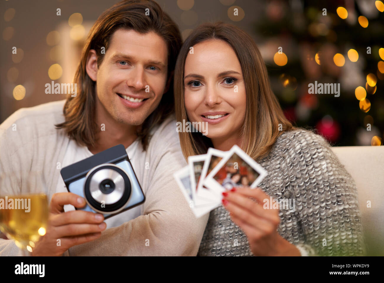 Schönes Paar feiert Weihnachten zu Hause und unter Instant Bilder Stockfoto