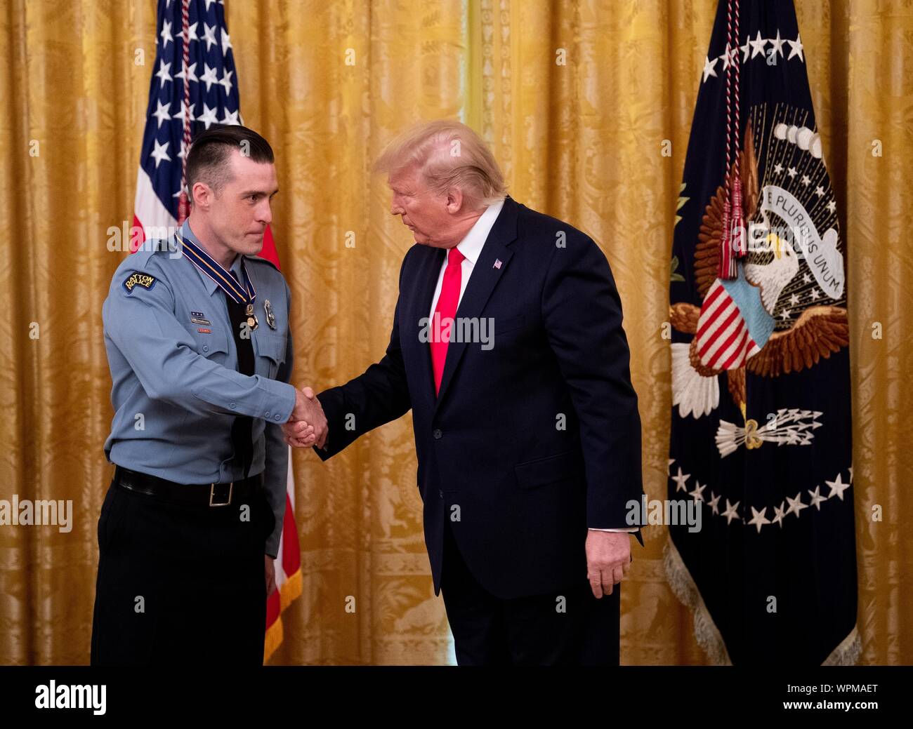 Washington, United States. 09 Sep, 2019. Präsident Donald Trump Auszeichnungen Dayton Polizisten David Denlinger der Public Safety Officer Medaille von Valor, während einer Zeremonie im Osten Zimmer im Weißen Haus in Washington, DC am Montag, 9. September 2019. Trumpf erkannte die sechs Dayton Offiziere, die gestoppt eine Masse schießen Am 4. und 5 Zivilisten, die während einer Messe schießen auf einen Walmart in El Paso einen Tag vor geholfen. Foto von Kevin Dietsch/UPI Quelle: UPI/Alamy leben Nachrichten Stockfoto