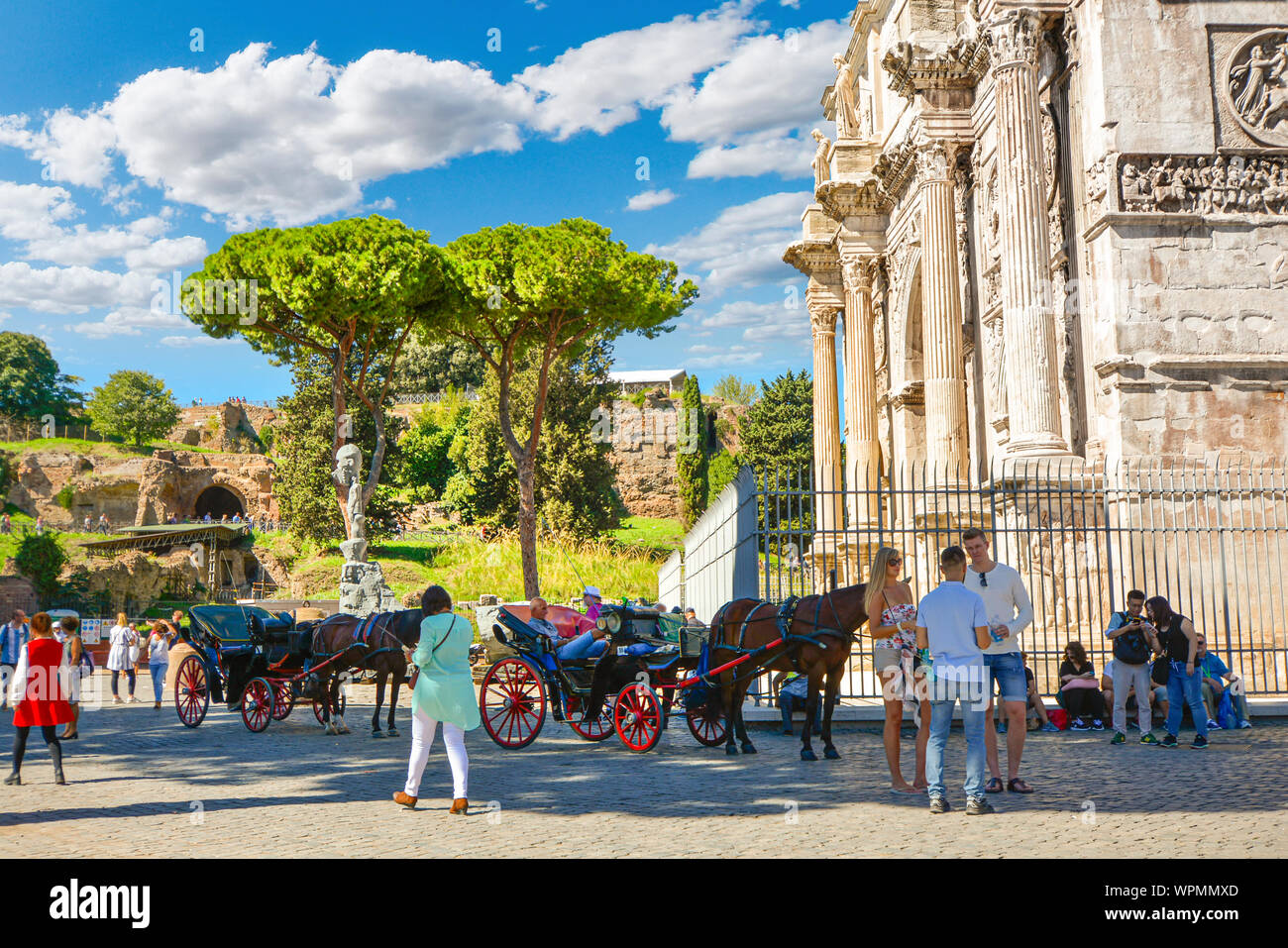 Touristen am Triumphbogen des Konstantin in der Nähe des Kolosseum und des Forum Romanum mit den kapitolinischen Hügel im Hintergrund als Pferd und Wagen warten, einstellen Stockfoto