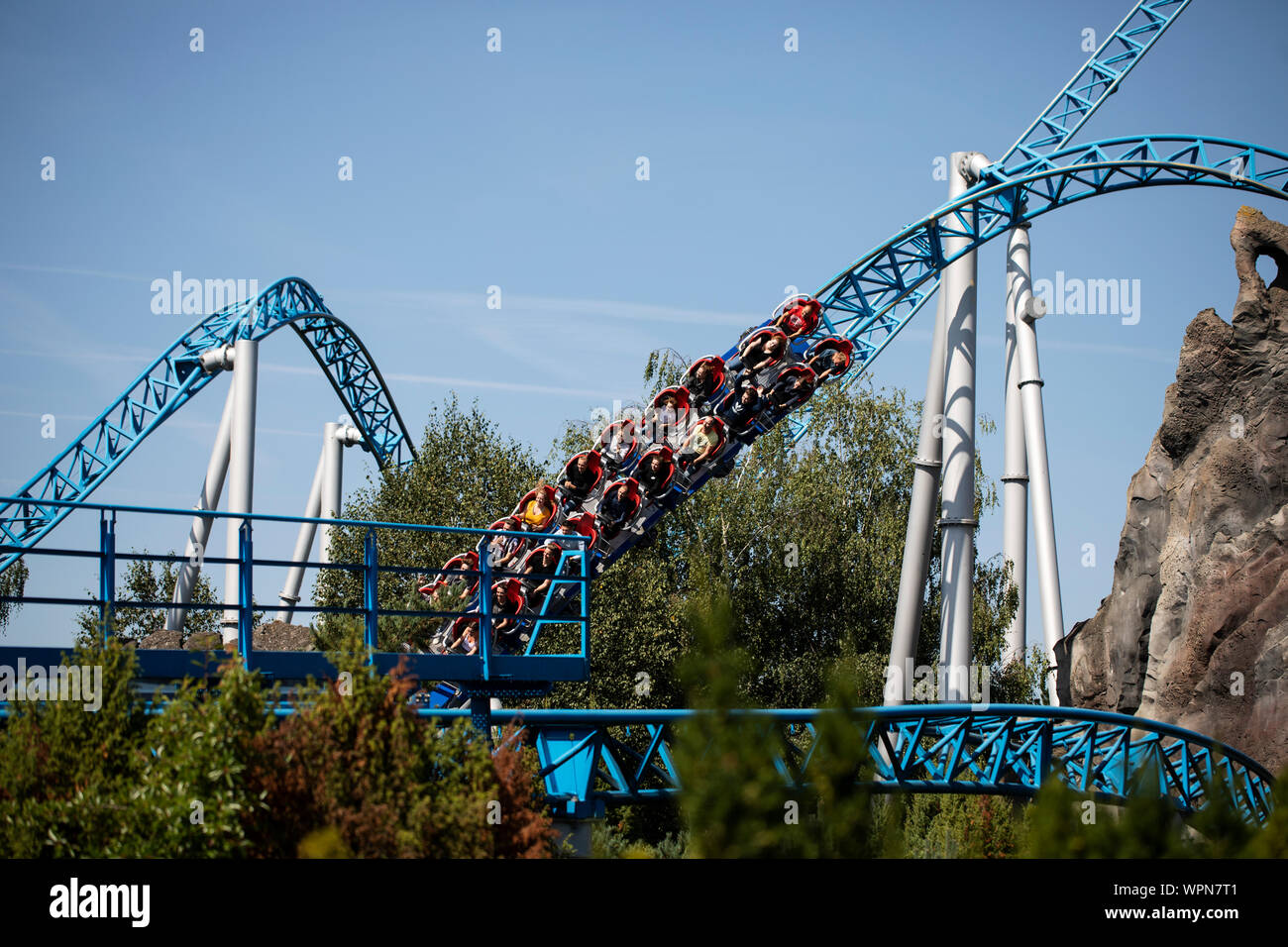 Die Fahrer fahren auf der Blue Fire Mega-Achterbahn im Europa-Park in Rust durch eine Kurve. Stockfoto