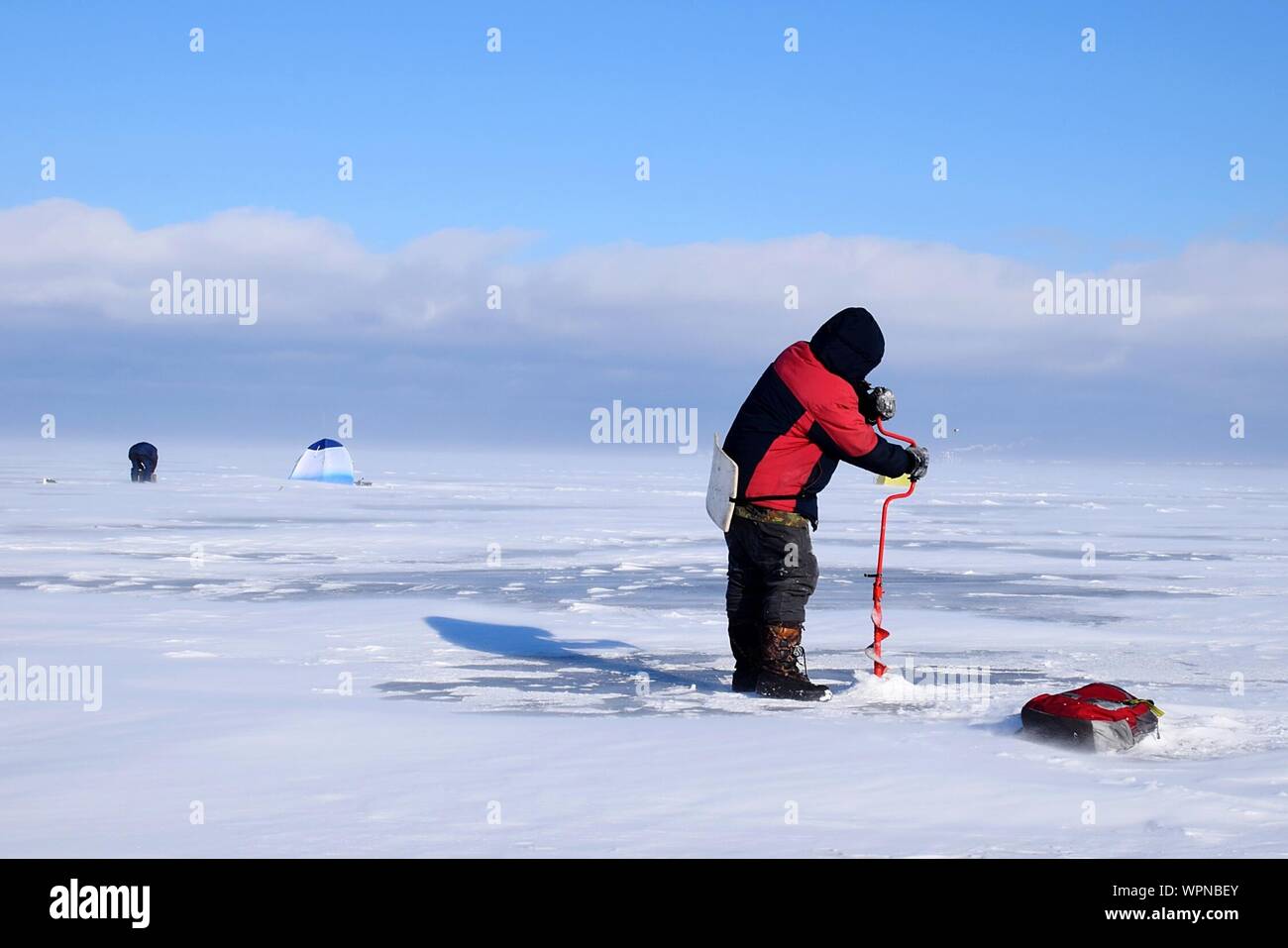 Man Bohren Loch im Eis Stockfoto
