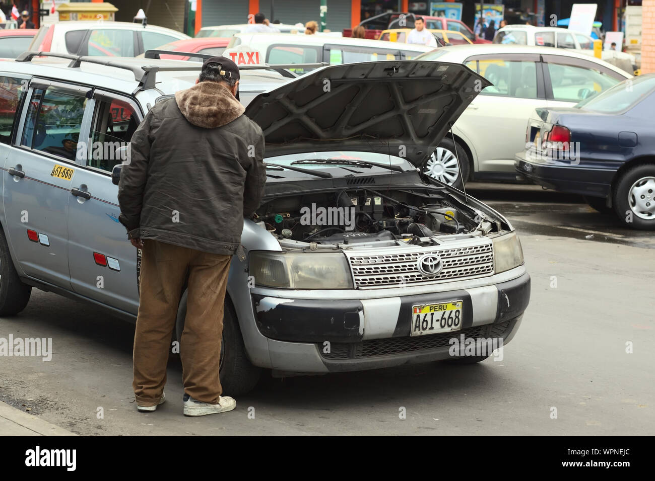 LIMA, PERU - 21. Juli 2013: Unbekannter Taxifahrer Überprüfung des Motors seines Autos am 21. Juli 2013 in Lima, Peru. Stockfoto