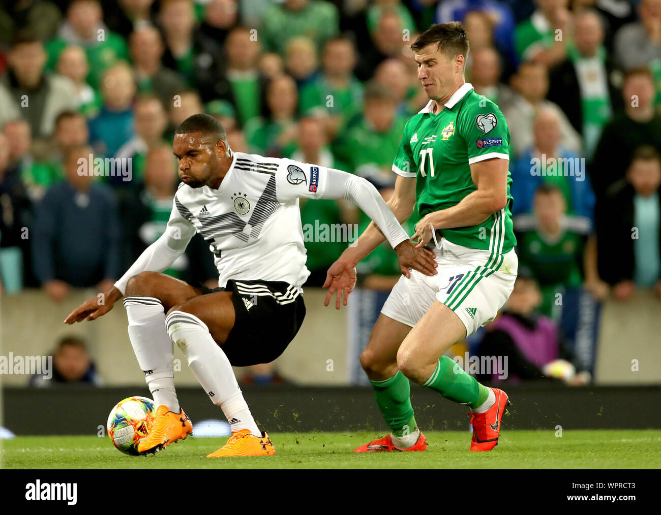 In Deutschland Jonathan Tah (links) und Nordirland Paddy McNair Kampf um den Ball während der UEFA EURO 2020 Qualifikation Gruppe C Match im Windsor Park, Belfast. Stockfoto