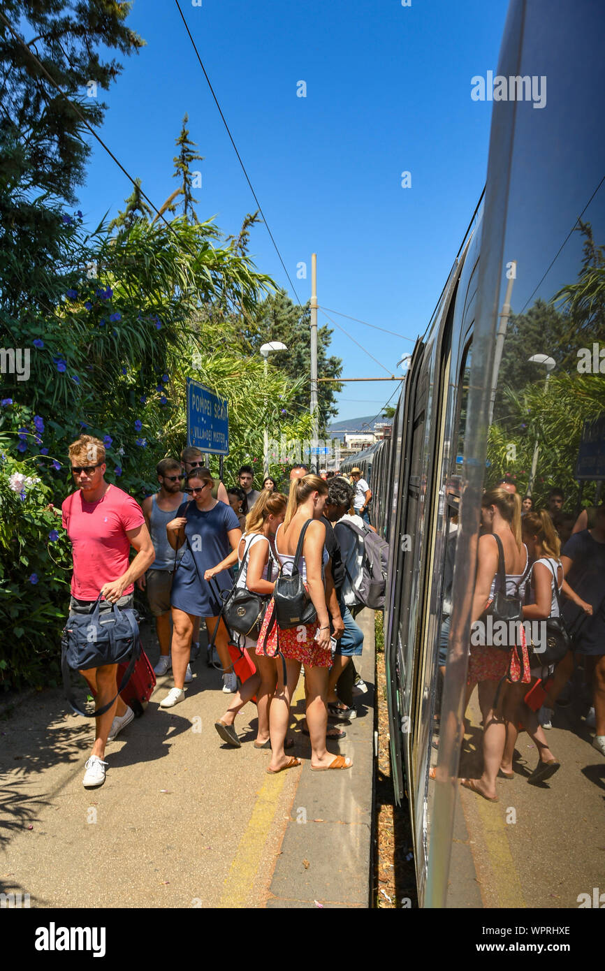 Pompeji, in der Nähe von Neapel, Italien - AUGUST 2019: Leute fangen einen Zug bei Pompeii Scavi Station, während andere sind zu Fuß entlang der Plattform zum Ausgang Stockfoto