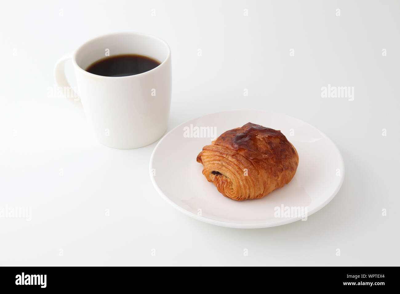 Französisches Brot Pain au Chocolat Schokolade Croissant auf Platte mit Tasse Kaffee auf weißem Hintergrund Stockfoto