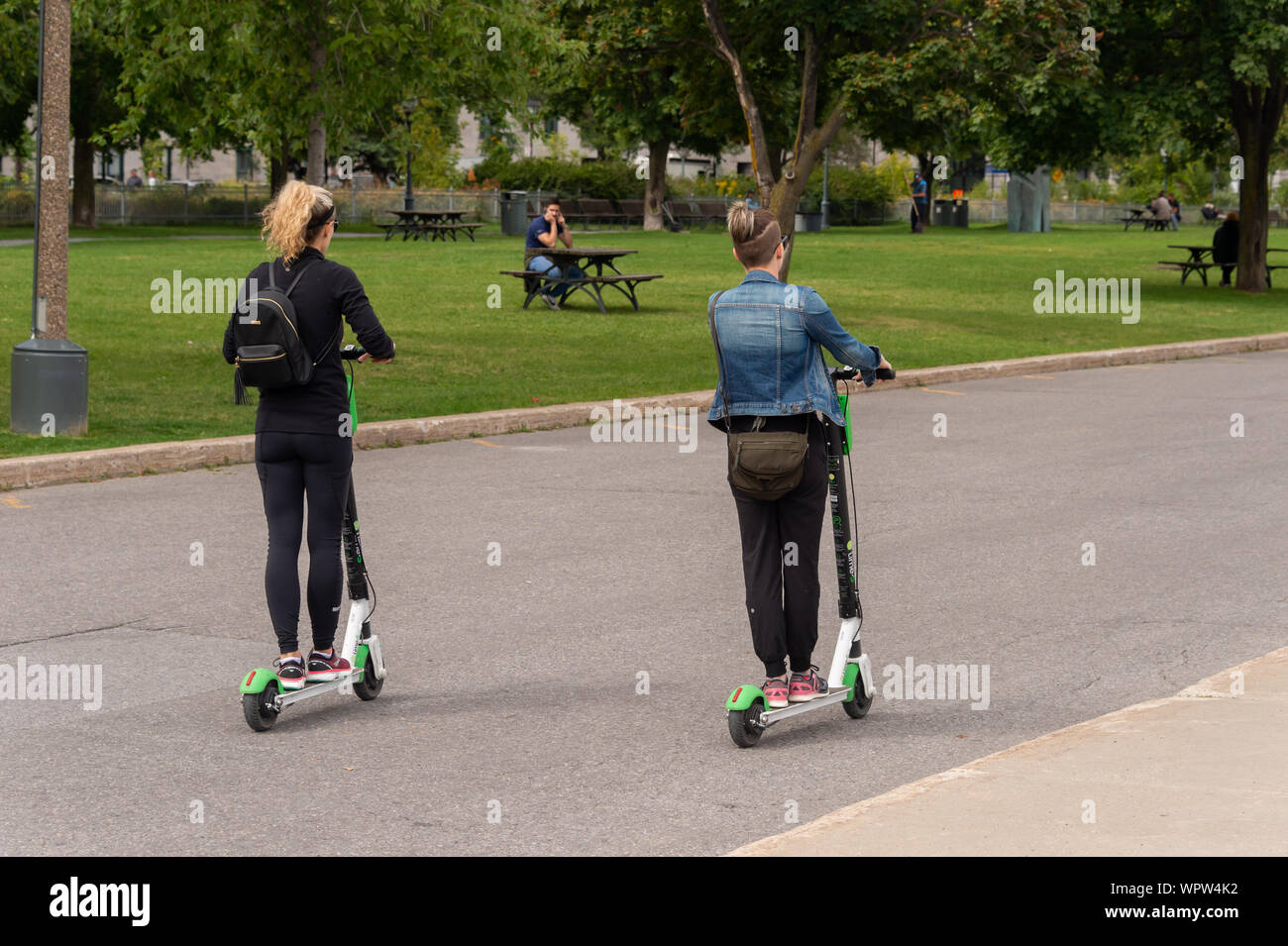 Montreal, CA - 7. September 2019: Zwei Frauen reiten ein Kalk Elektroroller Stockfoto