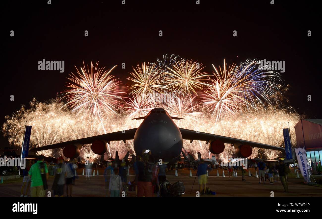 Spektakuläres Feuerwerk hinter massiven Lockheed C-5 M Super Galaxy Flugzeug Boeing Plaza, der EAA AirVenture Oshkosh, Wisconsin, USA geparkt explodieren Stockfoto