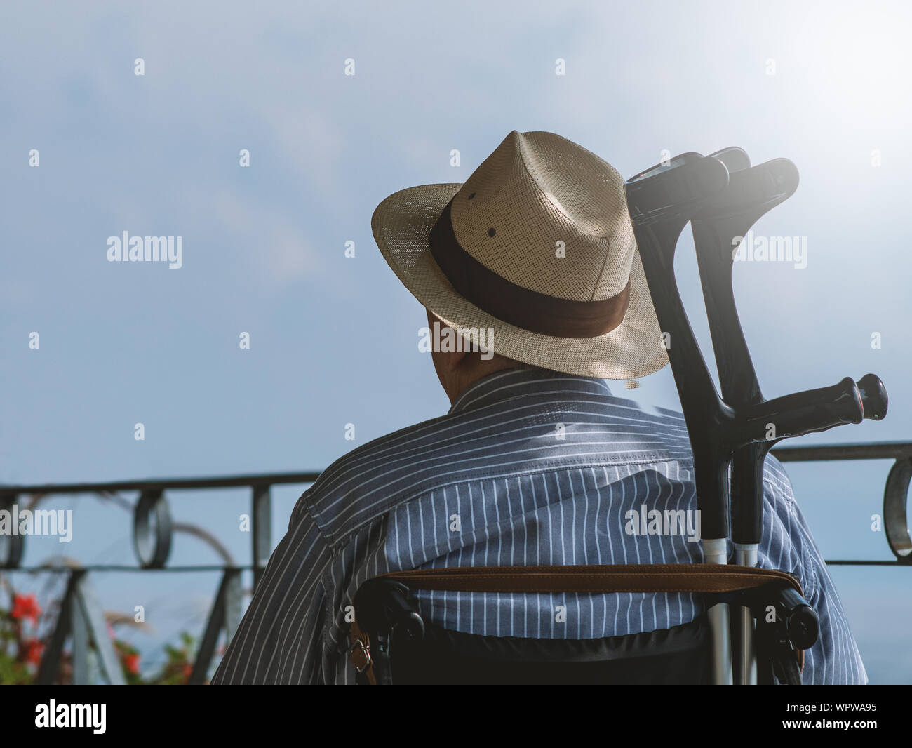 Senior mit Rollstuhl sitzen draußen in der Sonne Stockfoto