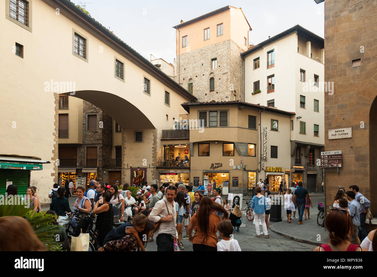 Street Scene mit Fußgänger, Fahrräder, Restaurants und Geschäfte am Schnittpunkt von Borgo S. Jacopo und Ponte Vecchio. Florenz, Italien Stockfoto