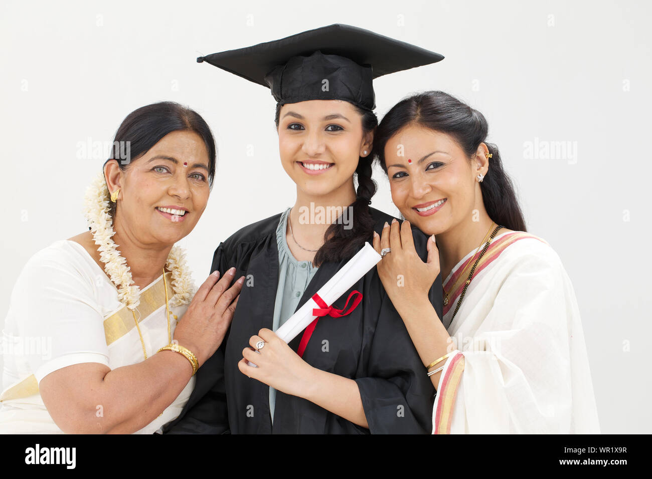 Studentin steht mit ihren Eltern und lächelt Stockfoto
