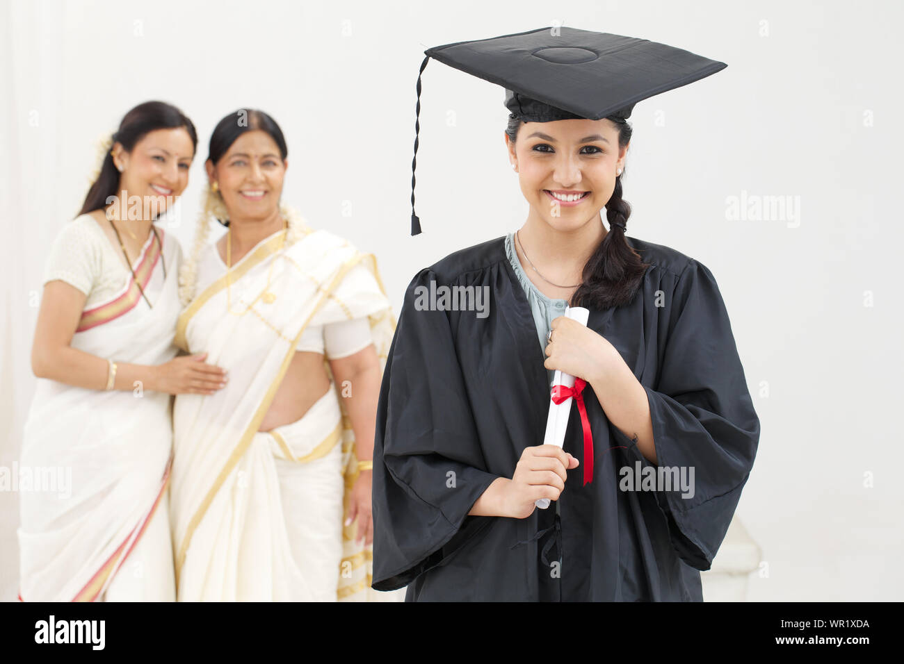 Graduate Student Abschlussgrad mit ihrer Familie in der Hintergrund Stockfoto