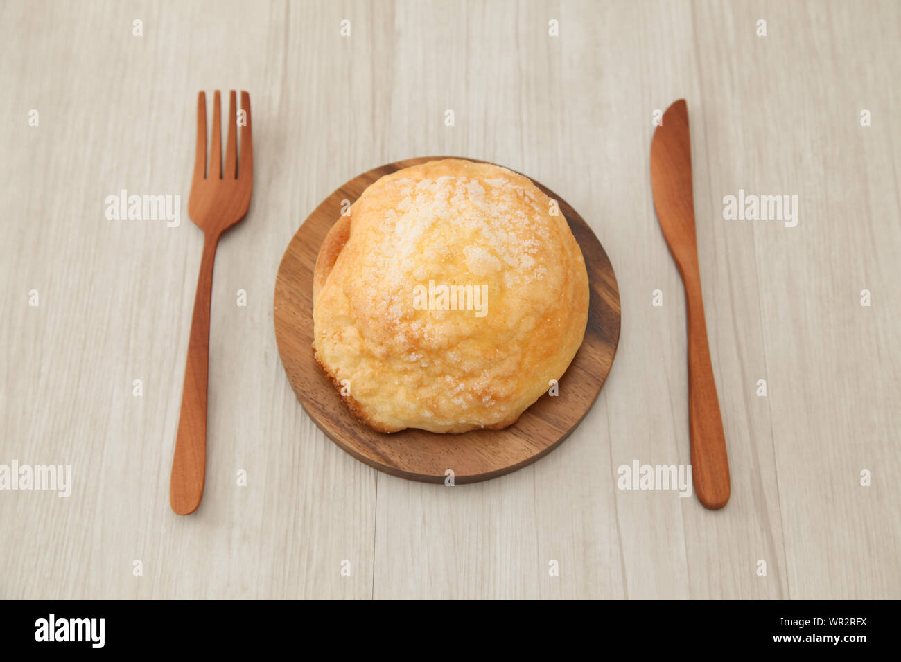 Zucker Brot melon Pan auf Holzplatte Gabel Messer closeup auf Tabelle isoliert Stockfoto
