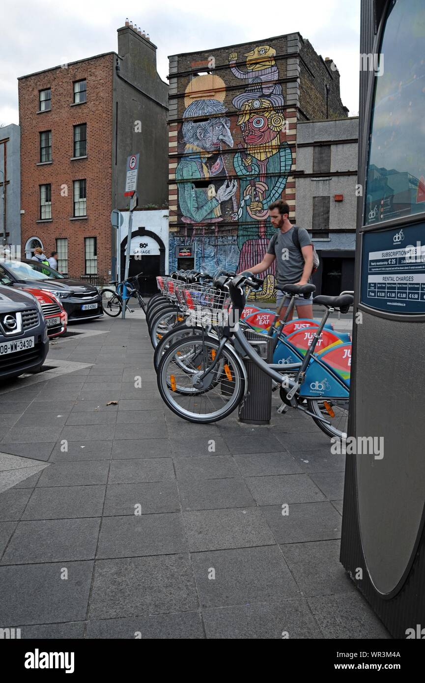 Ein Mann kehrt ein Fahrrad an eine Docking Station in einer Reihe von nur Essen gesponsert Dublin Fahrräder in Dublin, Irland Stockfoto