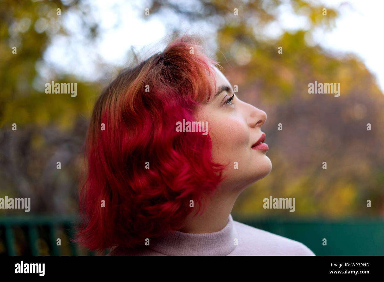 Schöne Frau mit rot gefärbten Haaren und den Hintergrund von Herbst gelbe  Blätter Stockfotografie - Alamy