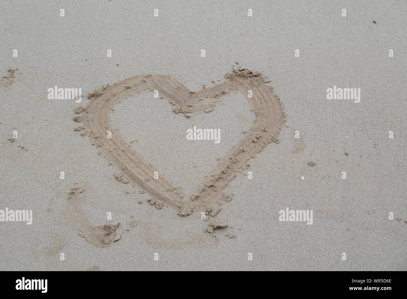 Herz im Sand am Strand, wie romantisch - Nordirland, Großbritannien gezogen. Stockfoto