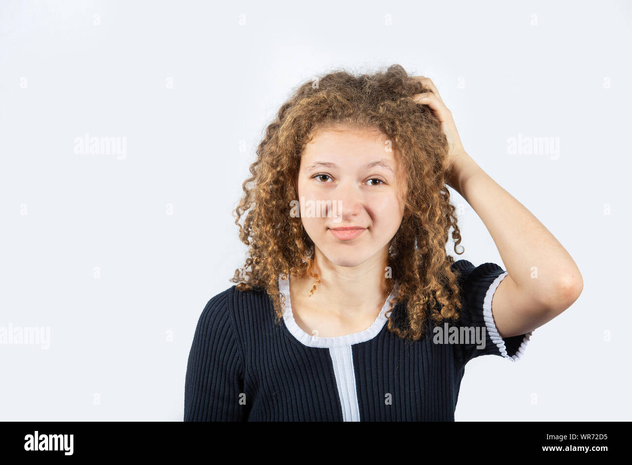 Verwirrt junges Mädchen den Kopf kratzen auf weißem Hintergrund frustriert. Menschliche Mimik, das Symbol der Körpersprache. Stockfoto