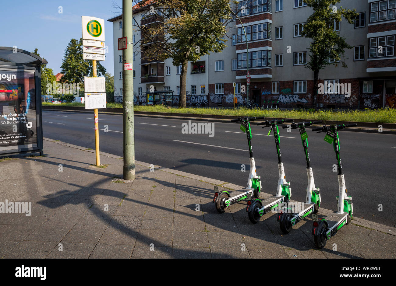 Kalk e-Scooter an einer Bushaltestelle im Bereich Berlin Neukölln geparkt, Deutschland Stockfoto