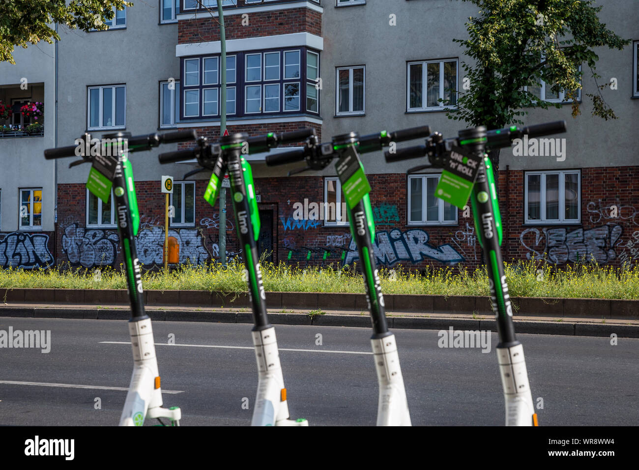 Kalk e-Scooter an einer Bushaltestelle im Bereich Berlin Neukölln geparkt, Deutschland Stockfoto
