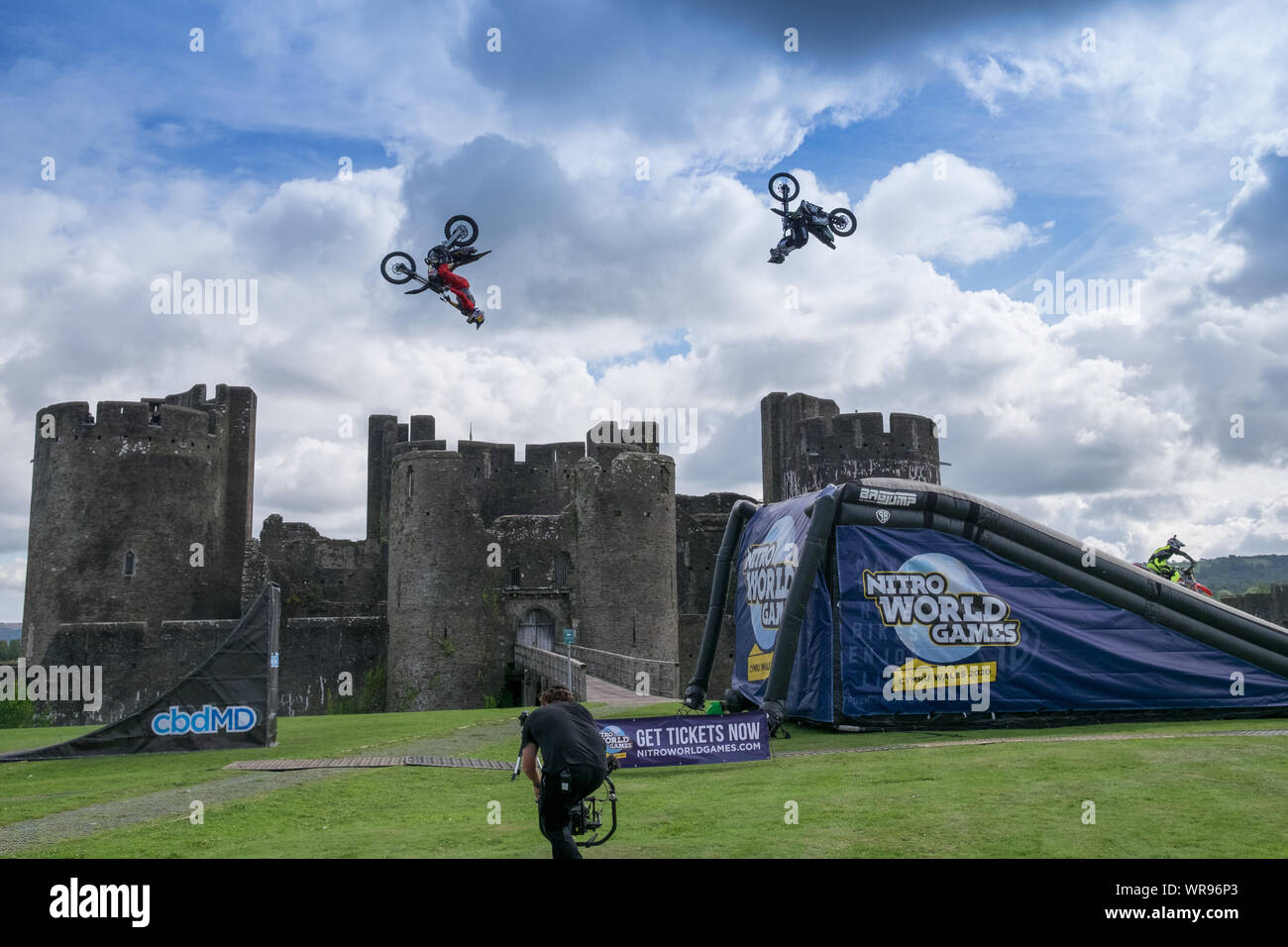 Caerphilly, Wales, Großbritannien. September 2019. Drei Freestyle Motor Cross (FMX)-Stars führen vor dem ebenso spektakulären Caerphilly Castle den noch nie dagewesenen „Synchronized double backflip train“ auf. Die Stuntperformer Jackson Strong, Josh Sheehan und Luc Ackerman gehören zu den erfolgreichsten FMX-Stars der Welt. Die Ausstellung wirbt für die bevorstehenden Nitro World Games 2020, die im Fürstentum Stadium in Cardiff stattfinden. Quelle: Herr Standfast/Alamy Live Newsg Stockfoto