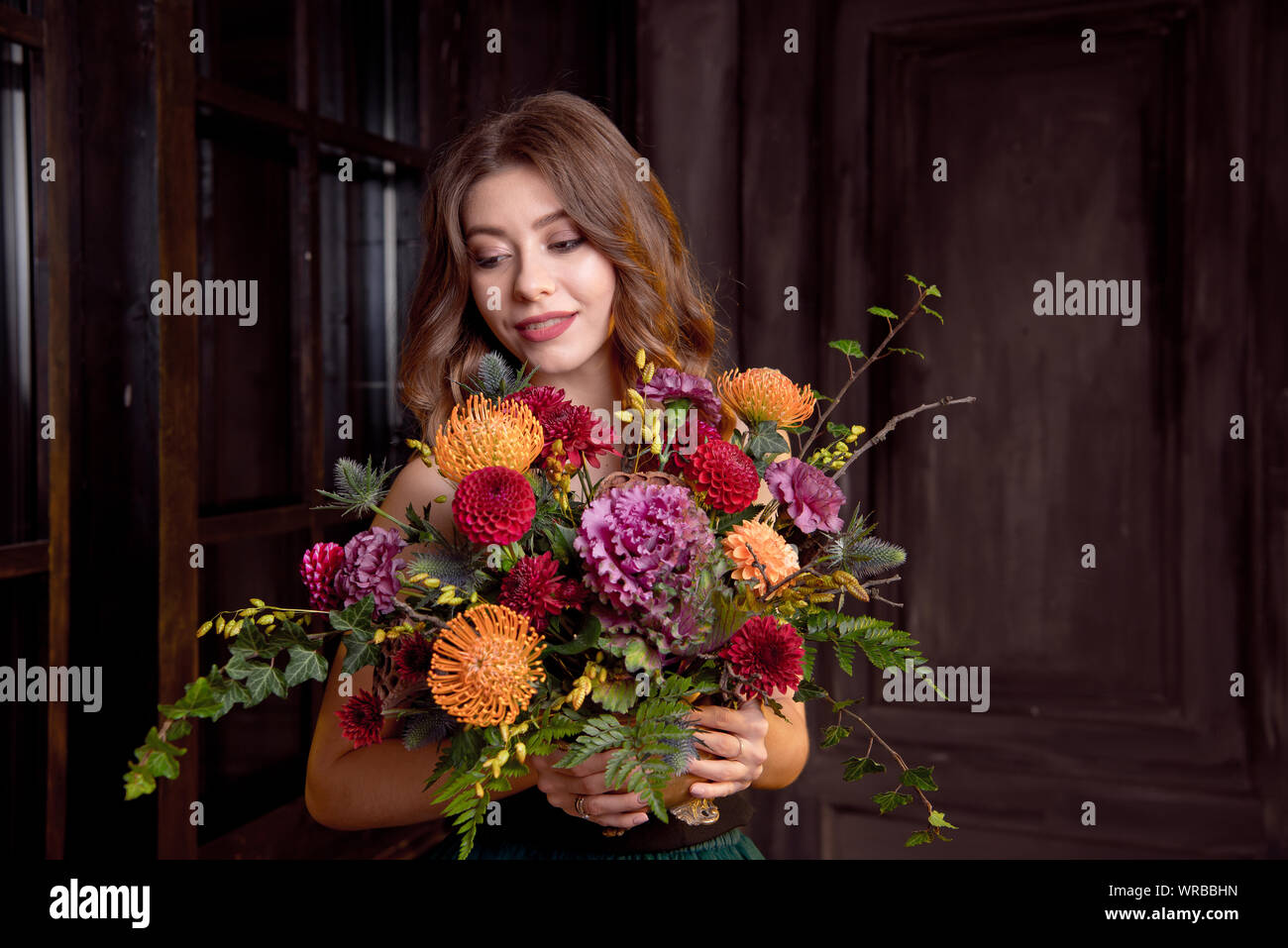 Halloween Party girl. Happy Halloween schöne Mädchen in einem schwarzen Top und Rock in ihren Händen hält einen Blumenstrauß mit Herbst Blumen. Stockfoto