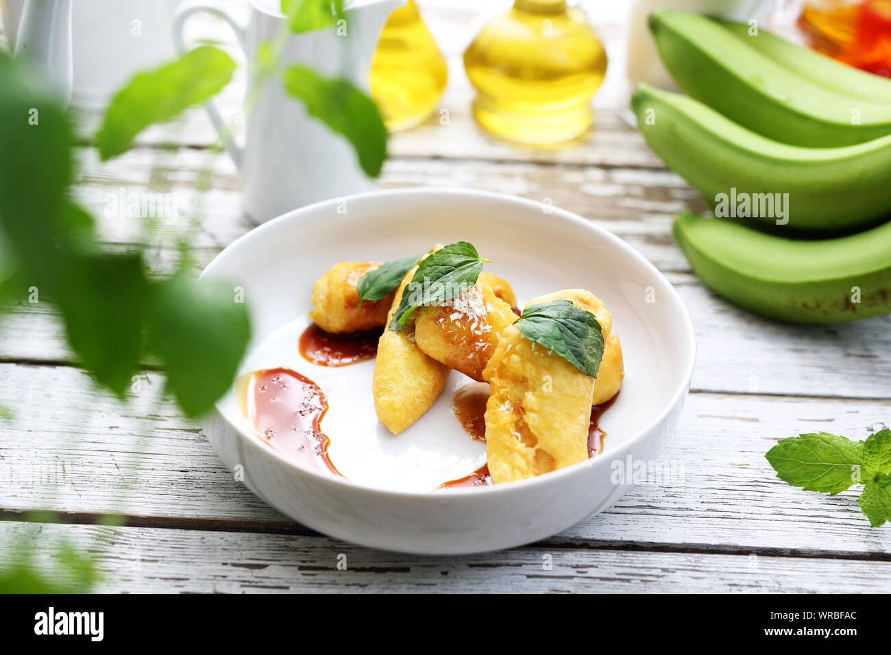 Bananen gebraten mit Karamellsauce und Kokosraspeln. Süße Nachspeise. Stockfoto
