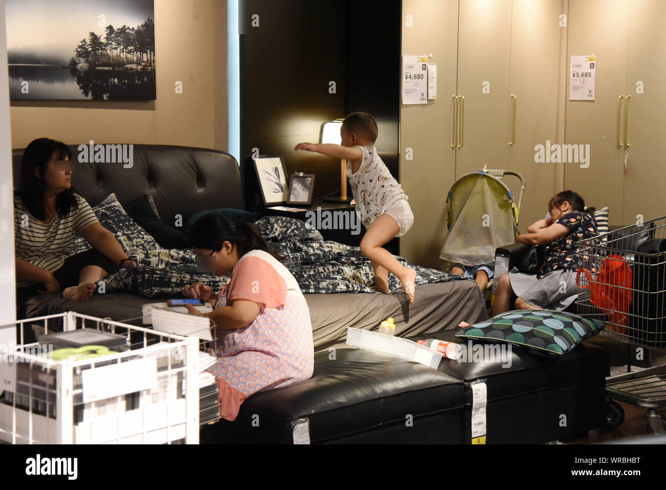Lokale chinesische Bewohner nap oder Ruhe auf dem Sofa oder auf dem Bett in einem klimatisierten IKEA Einrichtungshaus die Hitzewelle auf einem scorcher in Nanj zu entkommen Stockfoto