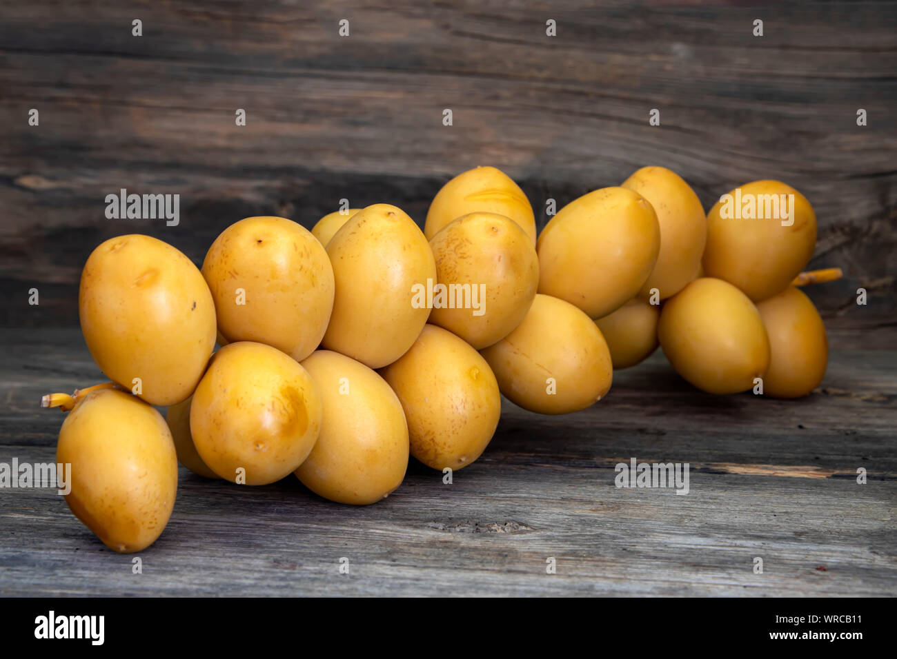 Sprig der reife, gelbe Termine close-up auf einem Holztisch Stockfoto