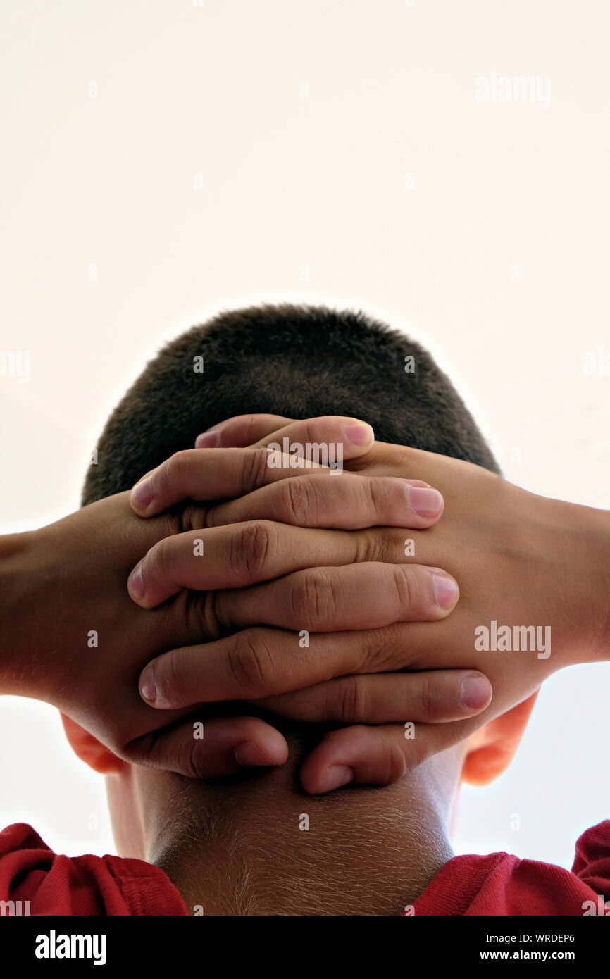 Nahaufnahme der Hände hinter am Hals Stockfoto
