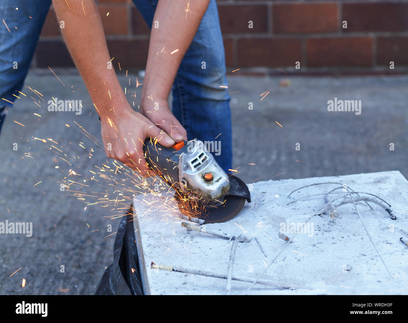Frau trennt, Metall mit einer Trennscheibe. Einhand Winkelschleifer. Flex von Beton Stockfoto